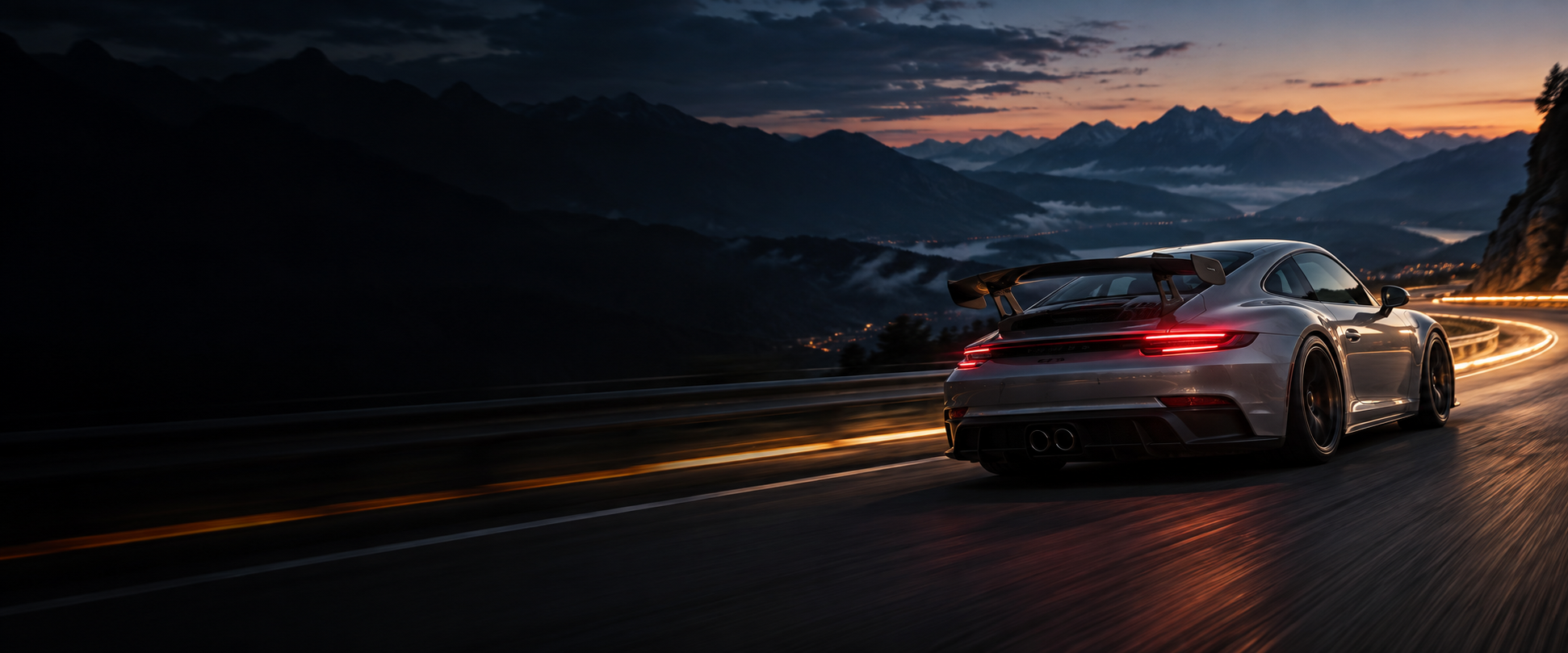 Voiture de sport argentée sur une route de montagne au crépuscule